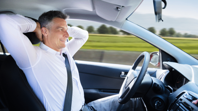 Man relaxing inside a self-driving car while commuting on a highway, showcasing the comfort and hands-free experience of autonomous vehicle technology.