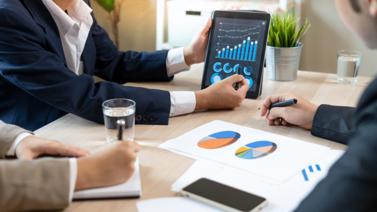 Financial advisor presenting business growth charts on a tablet during a meeting with clients.