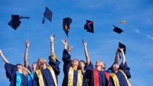 Group of diverse students celebrating graduation by throwing caps in the air, symbolizing achievement and success in education.