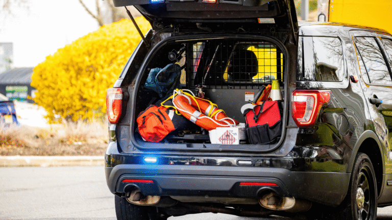 Emergency car accessories including safety kit, life preserver, and tool bags stored in the back of an SUV.