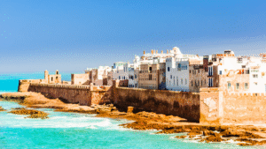 Coastal view of a historic fortified city in Morocco with whitewashed buildings and turquoise waters, representing scenic African destinations.