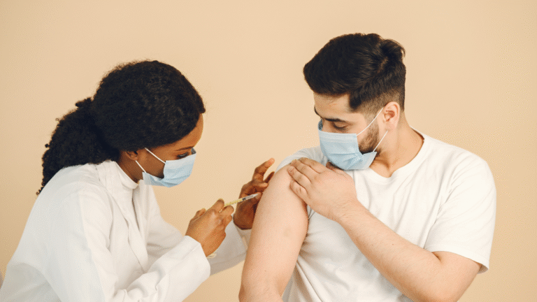 Doctor giving a vaccine injection to a man wearing a mask to help boost immune system protection.