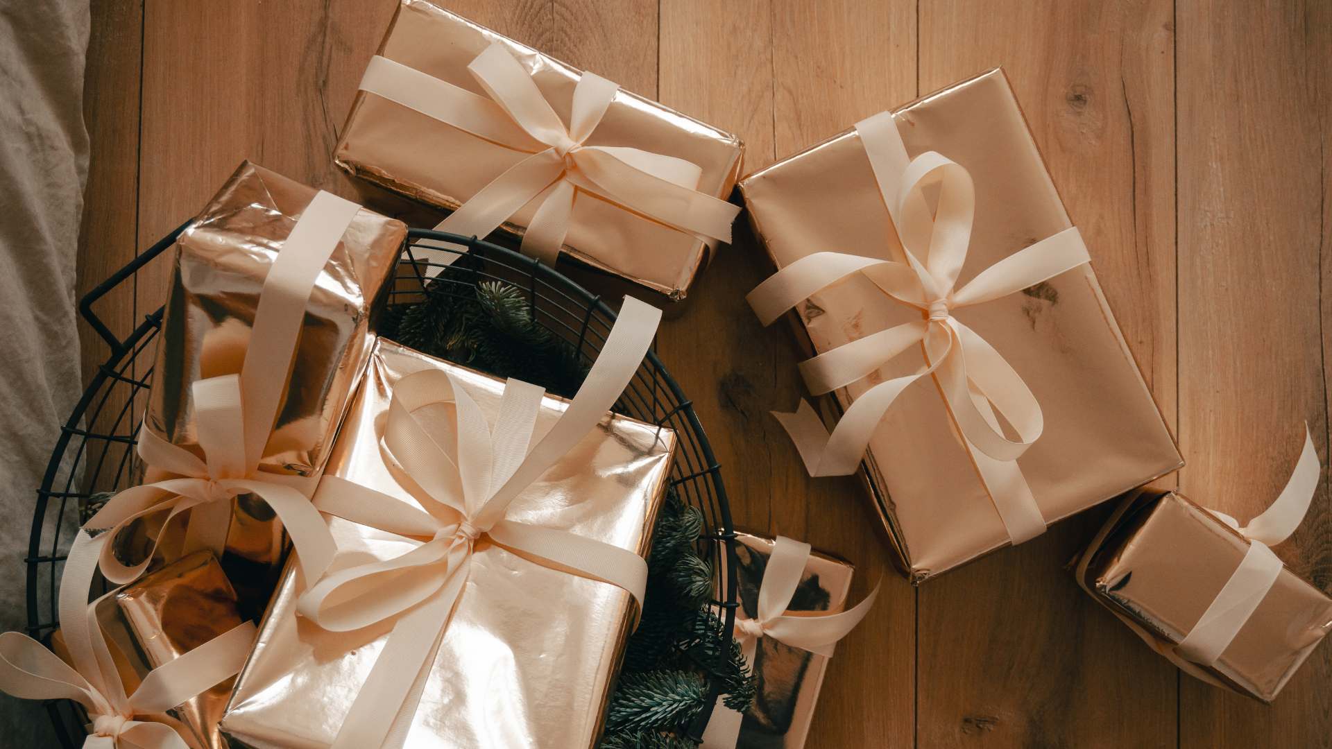 Beautifully wrapped presents with ribbons on a wooden floor, showcasing creative gift ideas.