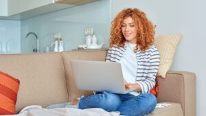Woman working on a laptop from home exploring side hustle opportunities