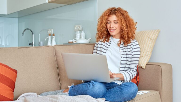 Woman working on a laptop from home exploring side hustle opportunities