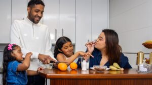 A happy family preparing breakfast together in a bright kitchen, showcasing small daily routines and micro-habits that transform your life through bonding, healthy eating, and mindful moments.