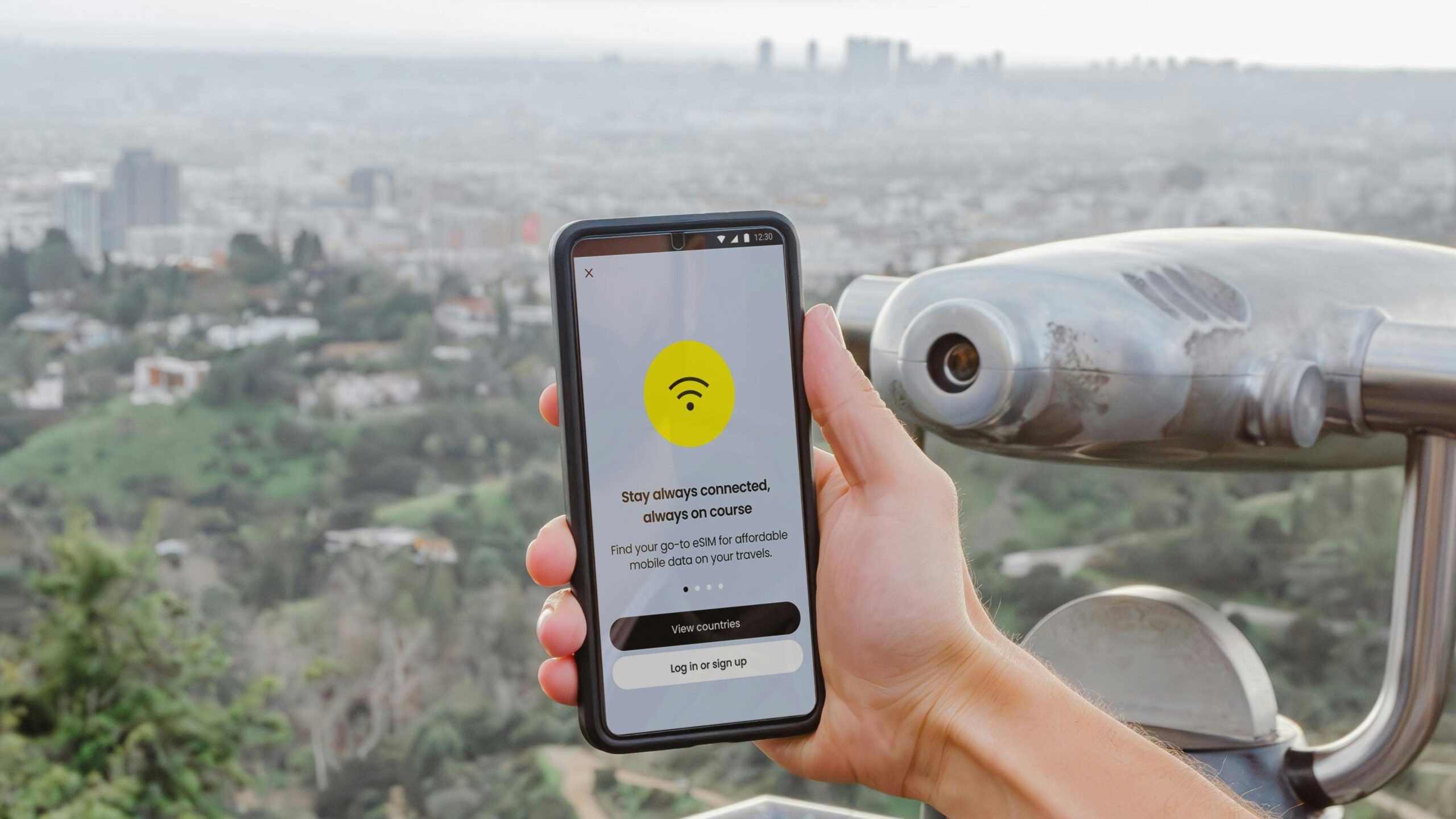 Smartphone showing an eSIM app interface overlooking a city viewpoint, illustrating the best eSIM apps for international travel in 2026 tested across multiple countries.
