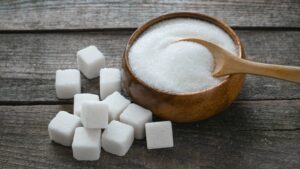 Too much sugar shown with sugar cubes and granulated sugar in a bowl, highlighting how excess sugar intake can cause side effects faster than you think