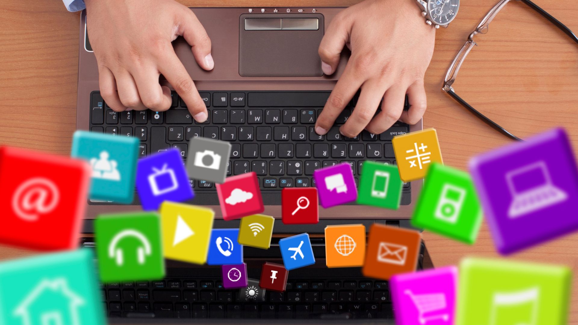 Person using a laptop with colorful icons representing popular Android apps