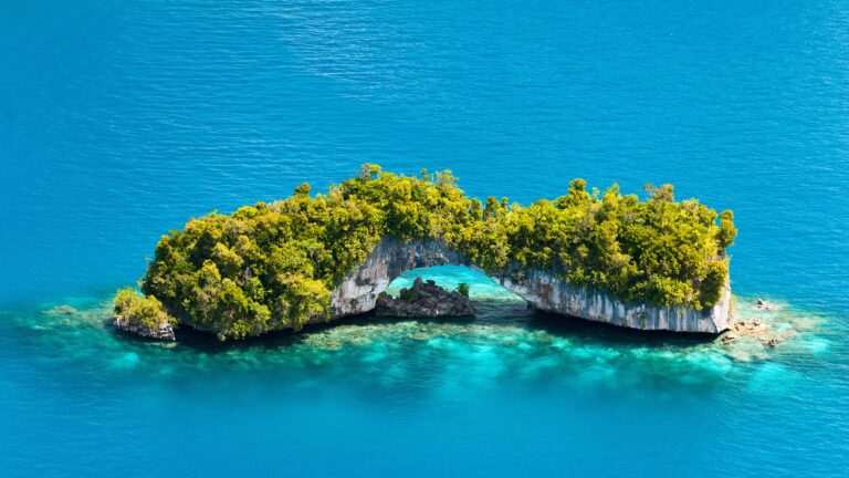 Beach Hopping in the Caribbean: Island with turquoise water, limestone cliffs, and lush greenery