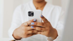 Person checking an iPhone while researching iphone battery drain issues and power usage.