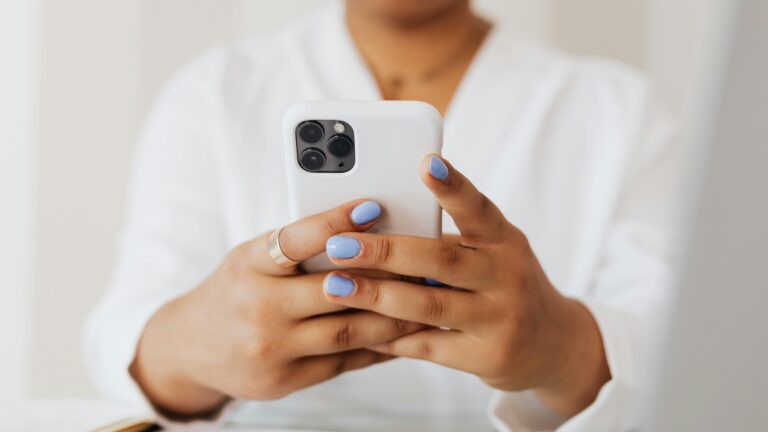 Person checking an iPhone while researching iphone battery drain issues and power usage.