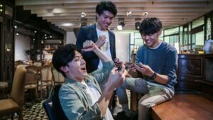 Friends playing mobile games together and celebrating a win