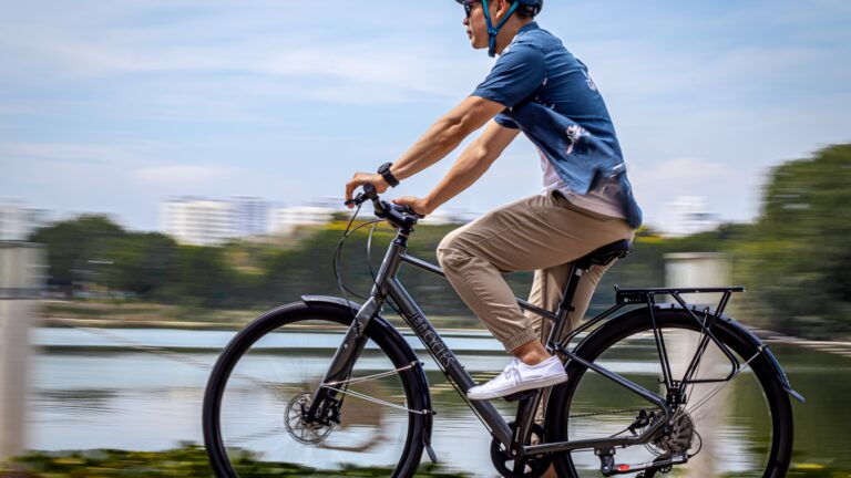 Man riding a bicycle during a scenic bike trip along a lakeside path
