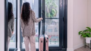 Minimal apartment interior with traveler and luggage, used in Is Airbnb Still Cheaper Than Hotels in 2025? comparison