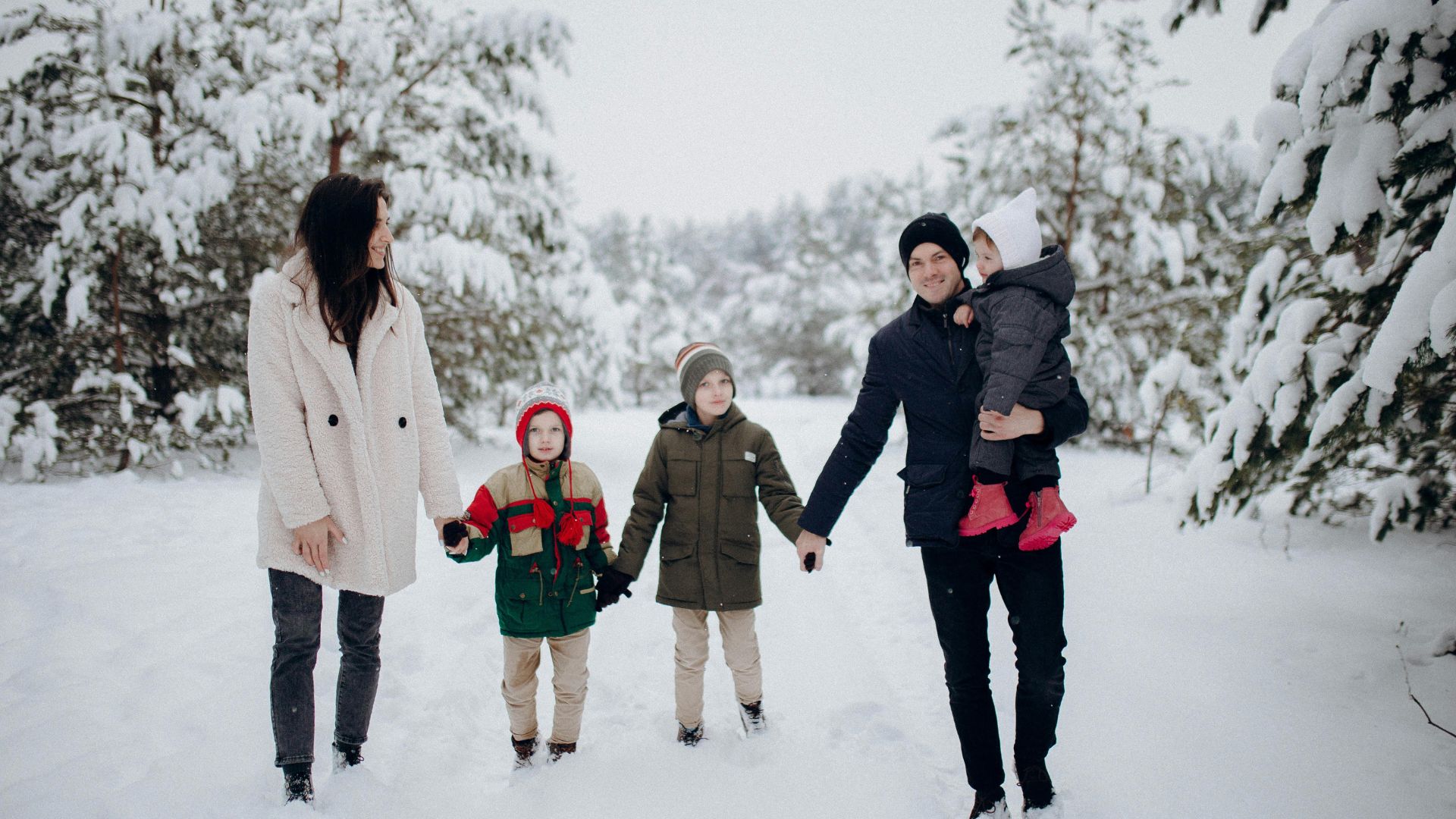 Family enjoying a snowy outdoor walk together during a Christmas Vacation