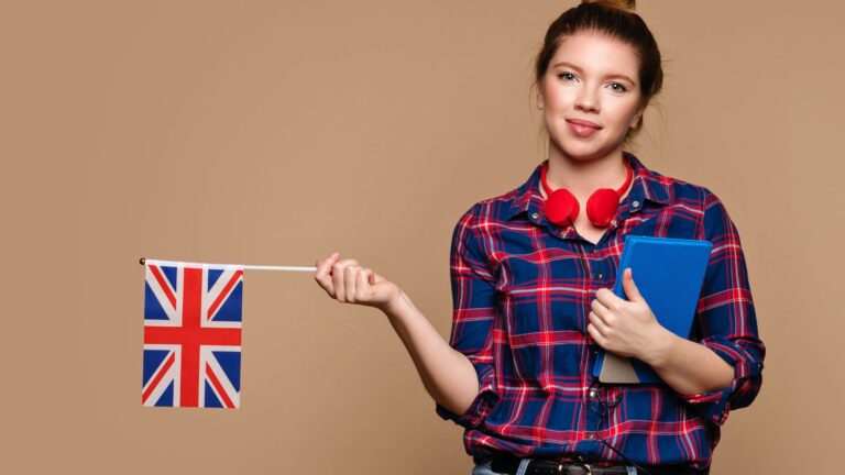 Student holding a UK flag and study materials while preparing to learn English