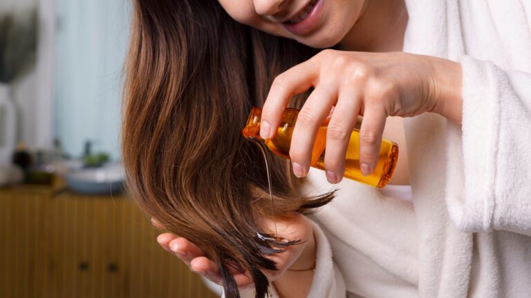 4. Woman applying argan oil for hair to repair dry and damaged ends