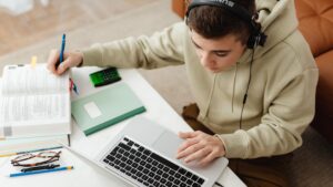 Student studying at a desk with laptop and books, showing practical ways of using ChatGPT for studying and note-taking