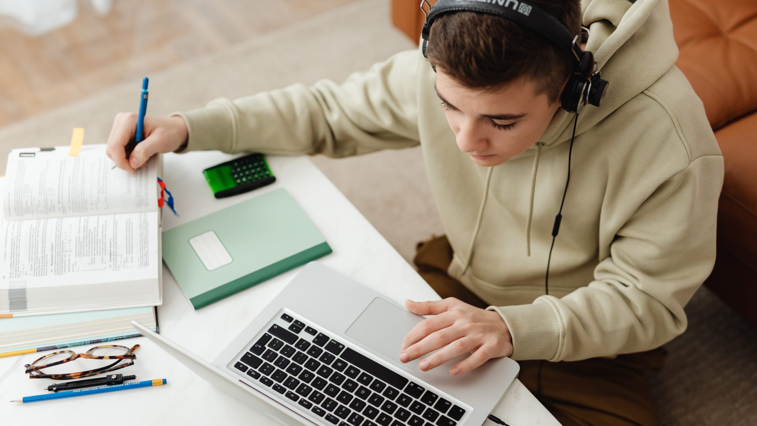 Student studying at a desk with laptop and books, showing practical ways of using ChatGPT for studying and note-taking