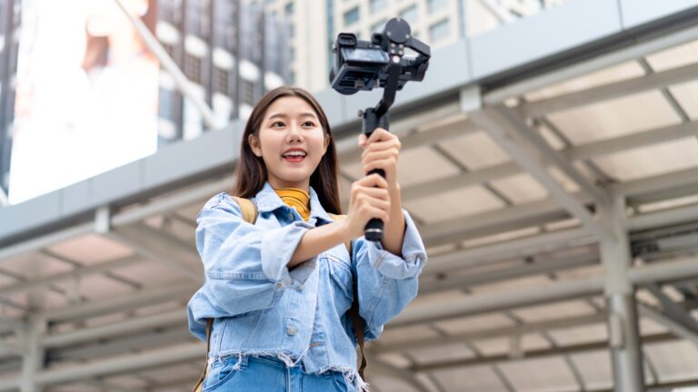 Travel creator filming a city vlog with a smartphone gimbal, showing how to shoot travel reels using only a smartphone.