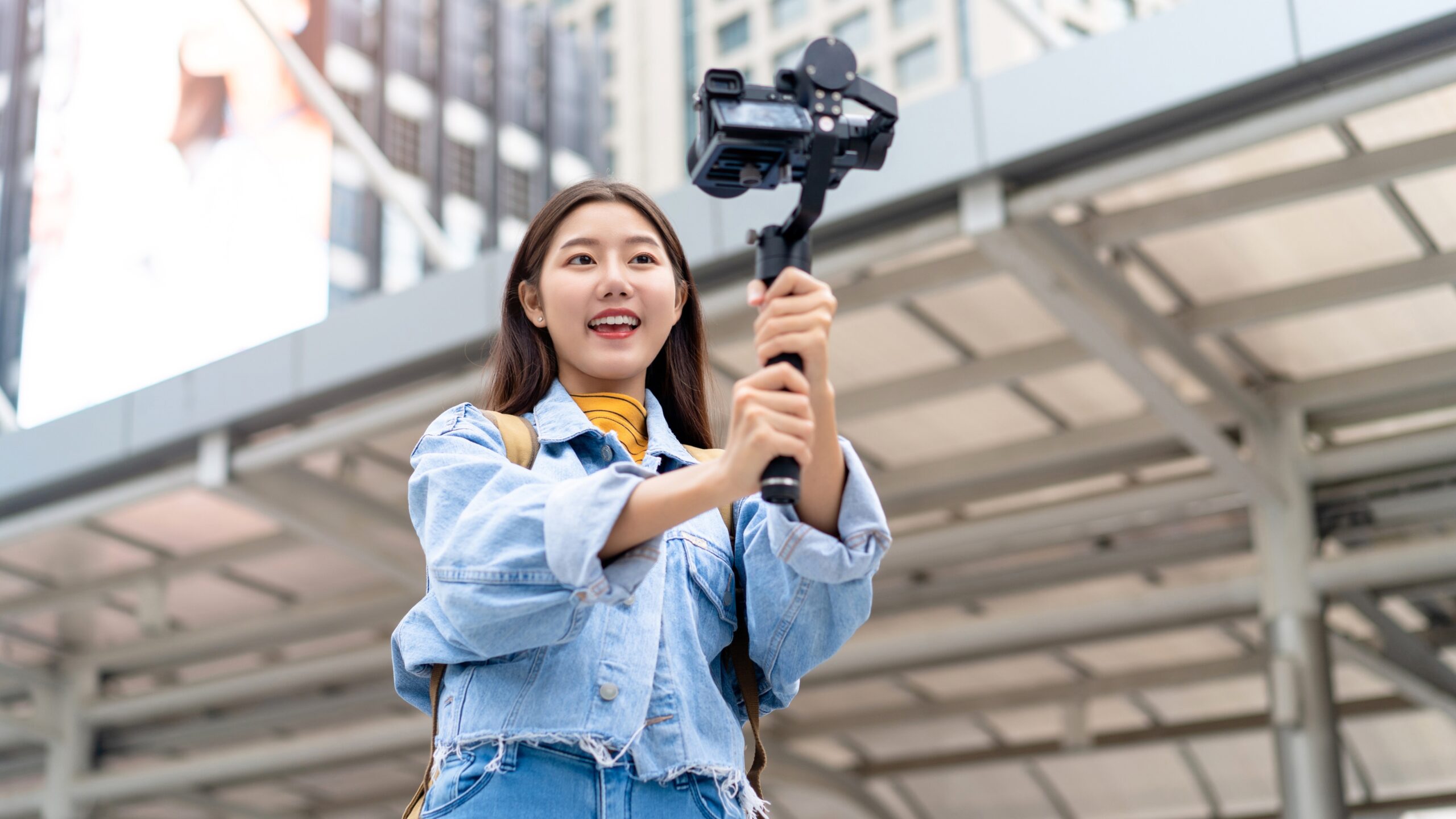 Travel creator filming a city vlog with a smartphone gimbal, showing how to shoot travel reels using only a smartphone.