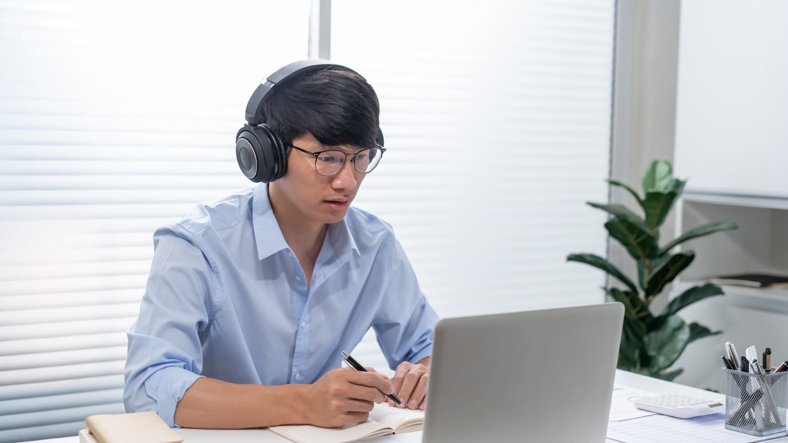 Student wearing headphones taking online notes on a laptop, representing Coursera vs Udemy vs YouTube: Which Is Best for Learning?