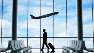 Best Apps for Navigating Airports and Flights Hassle-Free shown through a traveler walking with luggage inside a modern airport terminal