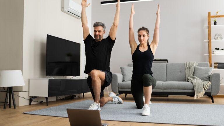 Couple performing lunges and overhead stretches during quick 20-minute home workouts for busy weekdays in a living room.