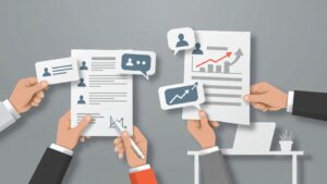 Hands reviewing resume documents and charts, illustrating how to build a resume as a recent graduate