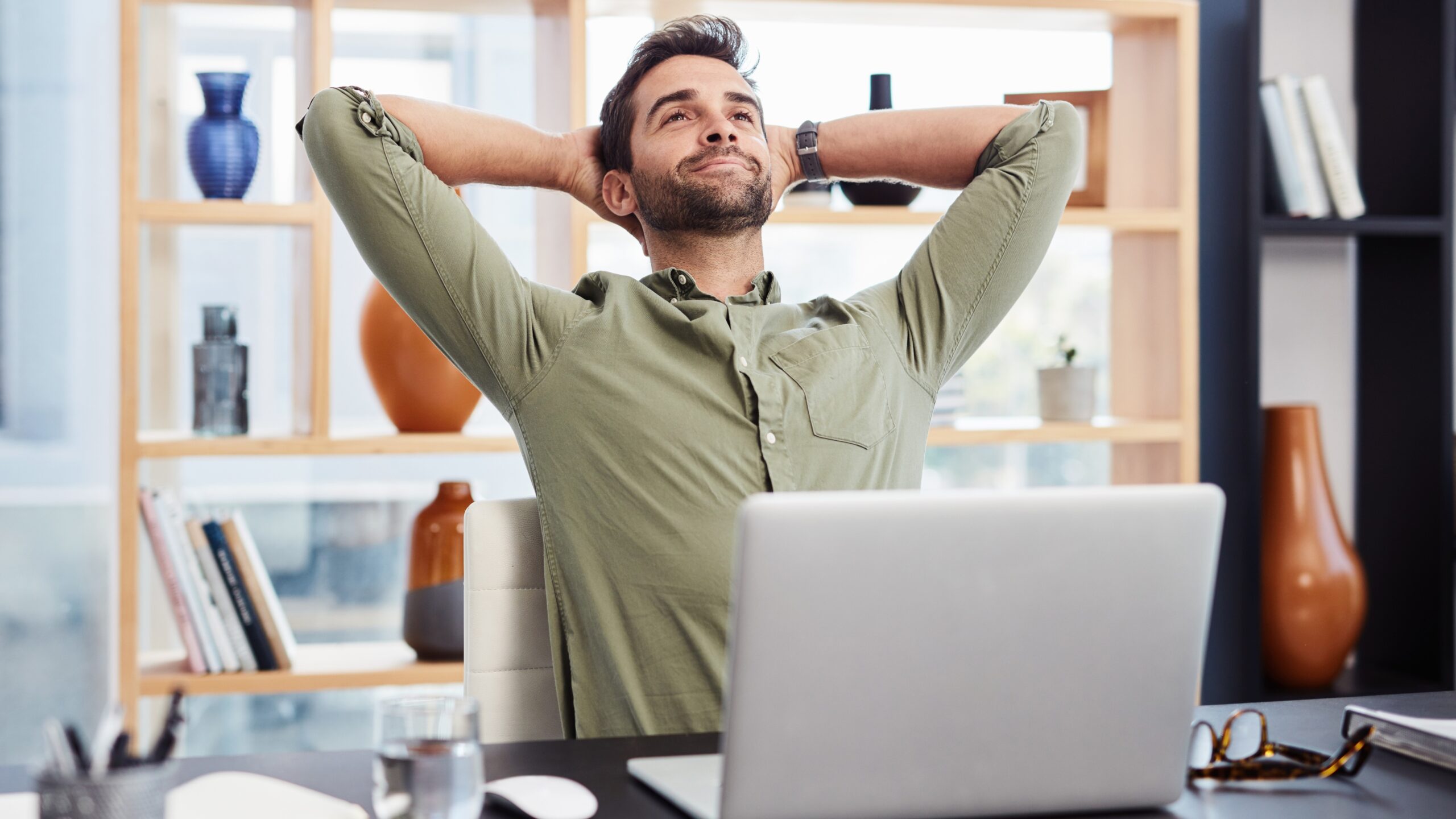 Relaxed man leaning back at a desk with a laptop, illustrating low-stress hobbies to try if you’re always busy