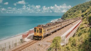 Train Journeys in India: Scenic Routes from Delhi to Kerala on a Budget featuring a coastal train passing along the sea